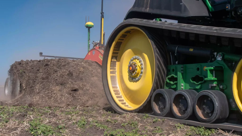 Close-up photo of Crawler John Deer tractor performing ground moving.