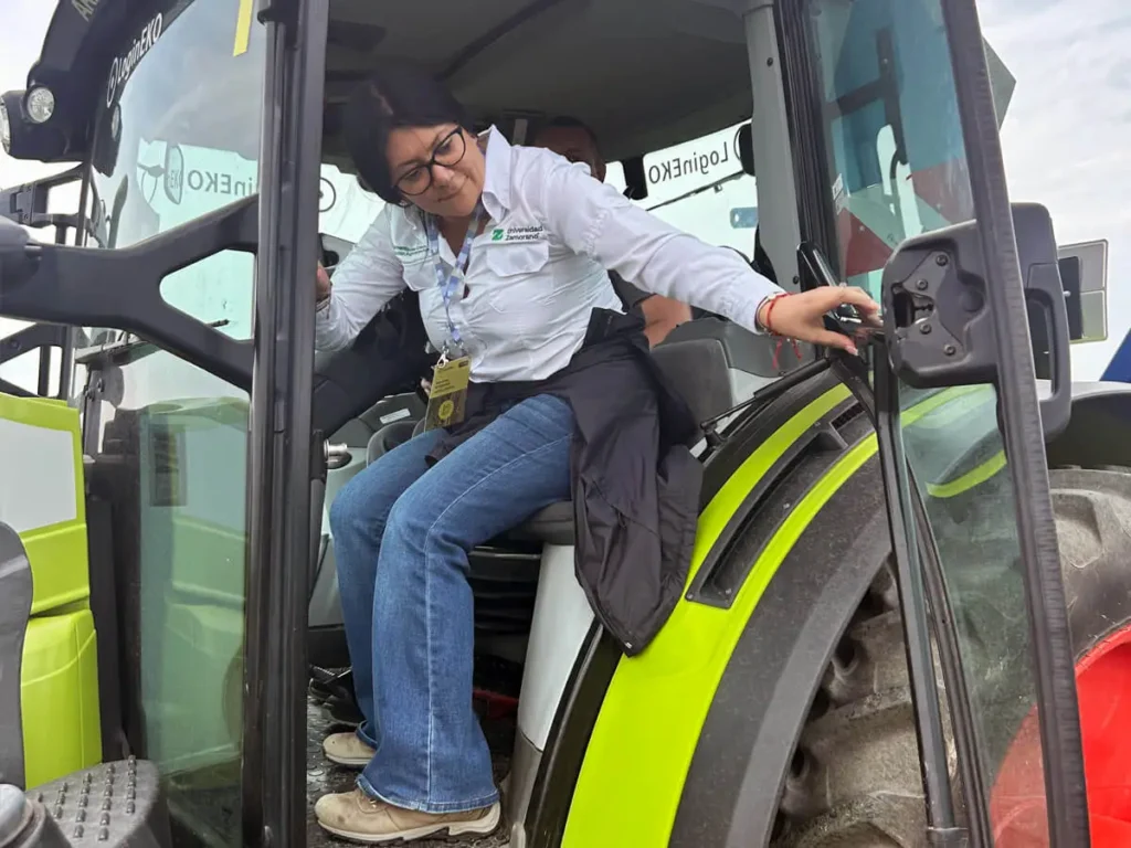 Participant climbing into the Smart Cabin of a Claas Arion tractor during a field demo at LoginEKO