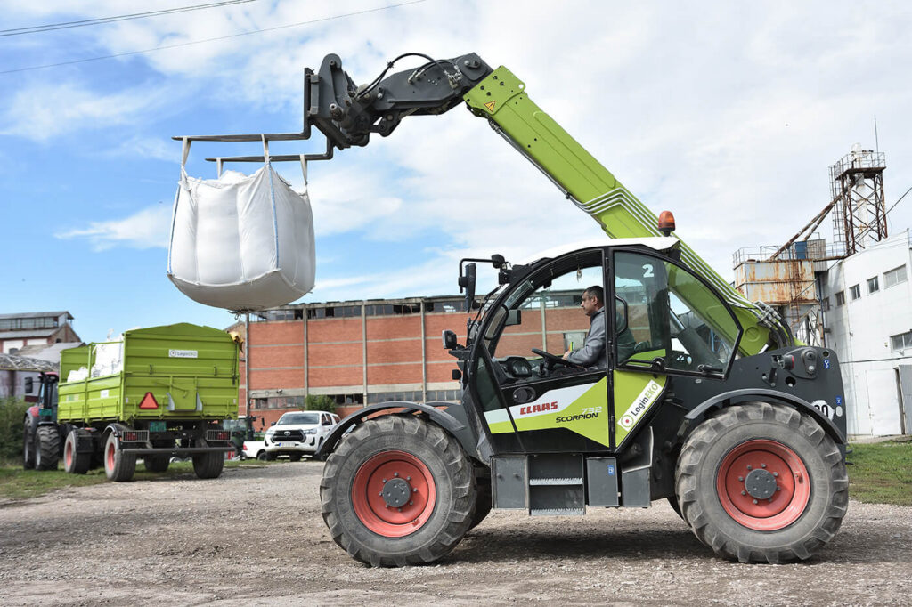 Telehandler loading a seed bag onto a trailer at the LoginEKO warehouse - farm warehouse management. 